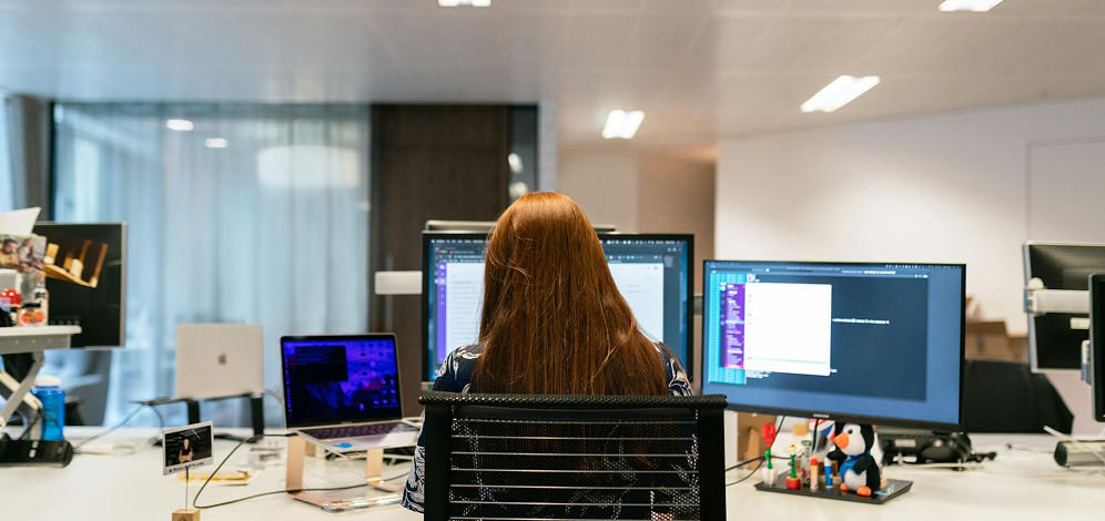 Government WordPress Services 2 a woman sitting at a desk with multiple computers