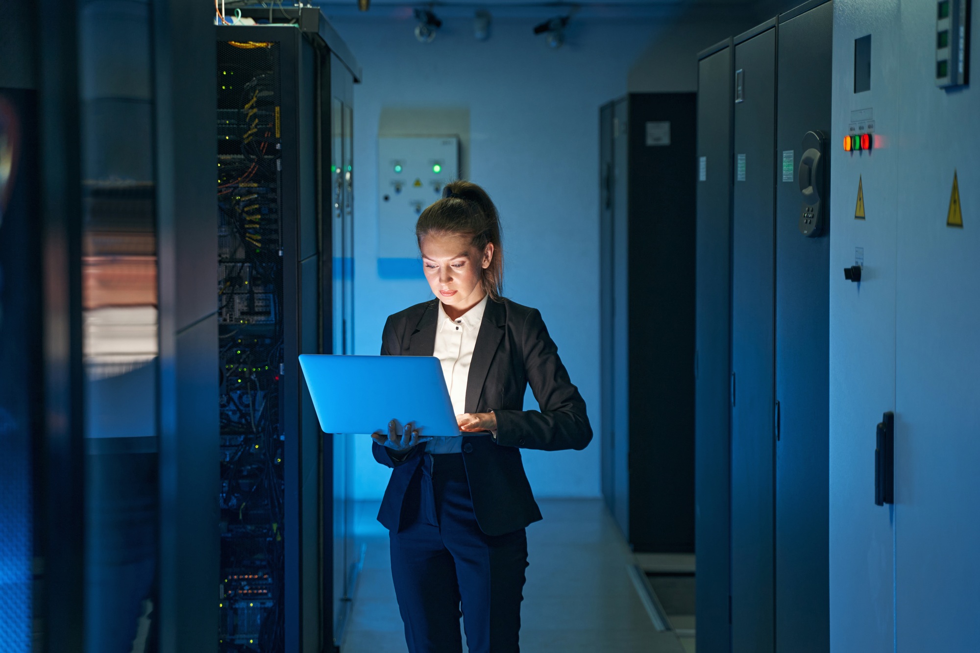 a woman in a suit holding a laptop