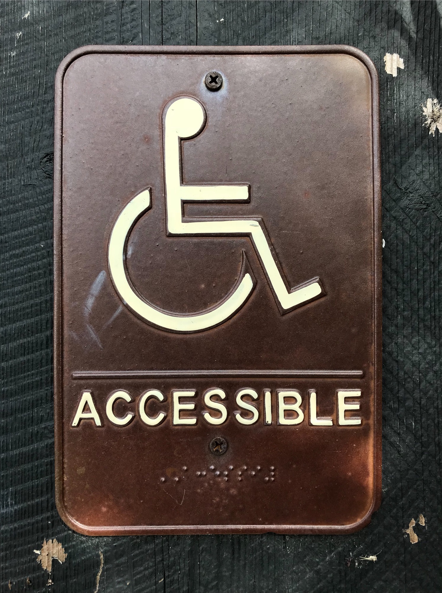 a brown sign with a white symbol on it