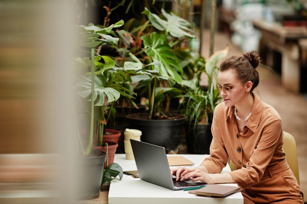 a woman sitting at a table with a laptop